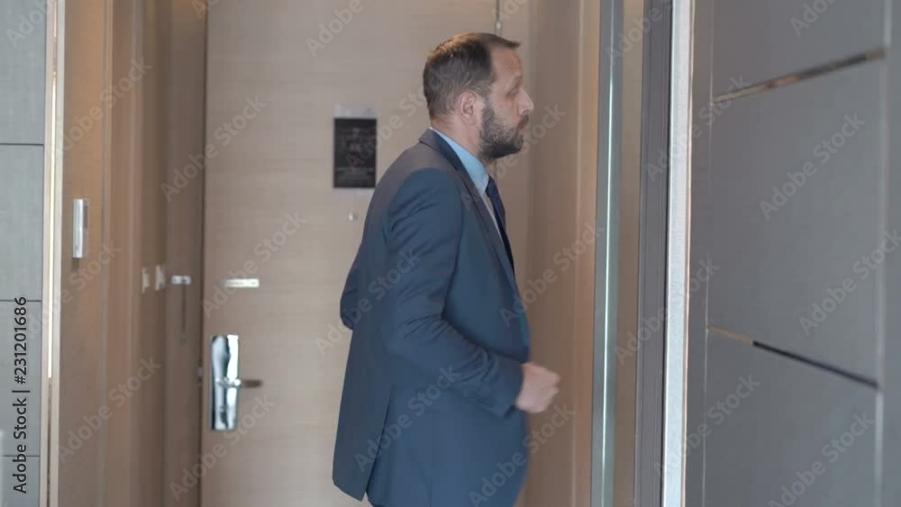 Businessman returns back to his hotel room and looks at oneself in the mirror Businessman returns back to his hotel room and looks at oneself in the mirror