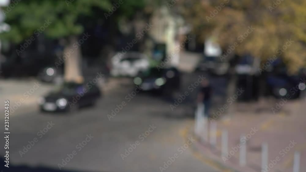 Day movement of cars and passing people put of focus Day movement of cars and passing people put of focus
