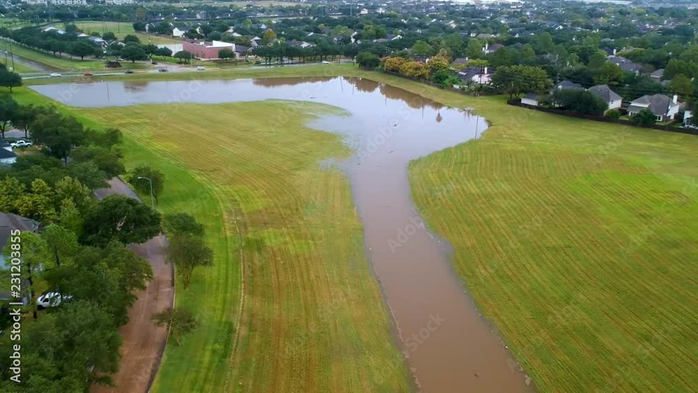 aerial pull back from flooded detention basin to subdivision aerial pull back from flooded detention basin to subdivision
