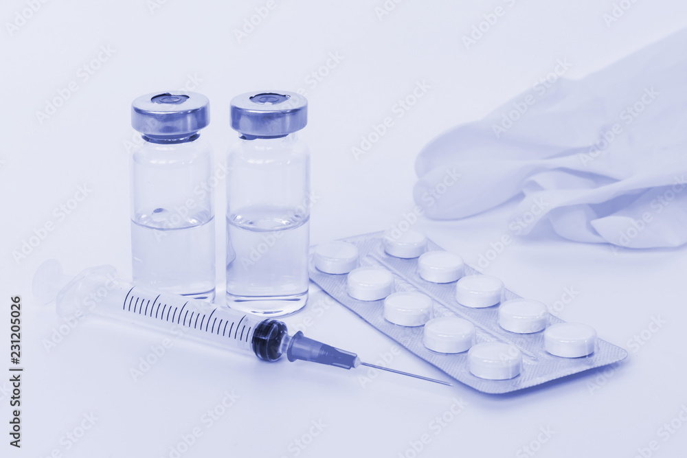Set of syringe, two vials, tablets and gloves toned light blue Set of syringe, two vials, tablets and gloves toned light blue