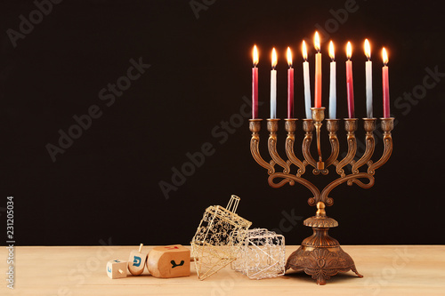 image of jewish holiday Hanukkah background with menorah (traditional candelabra) and burning candles. photo