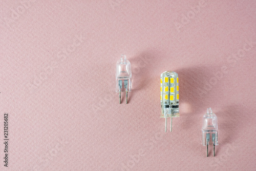 Two halogen and one modern eco LED type arranged diagonally on a pink background- technology shift photo