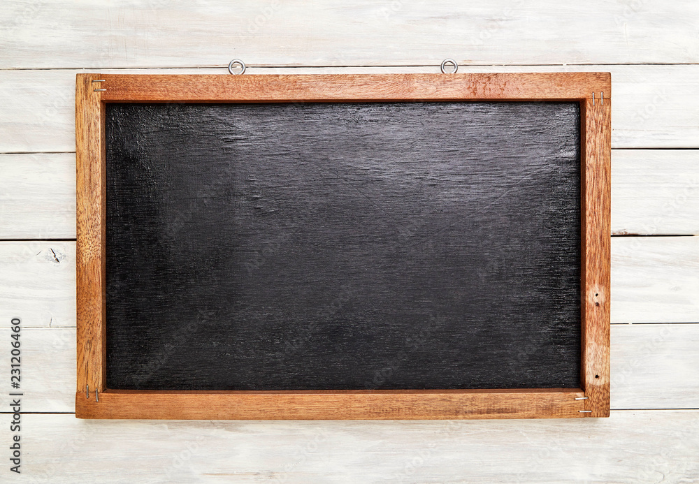 Blackboard in wooden frame on wooden wall Blackboard in wooden frame on wooden wall