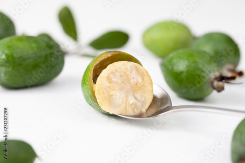 Fresh raw feijoa fruit on a spoon on white photo