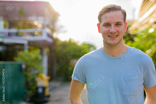 Young handsome man with blond hair in the streets outdoors