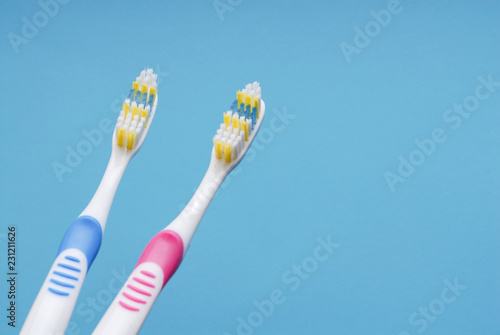 Pink and blue toothbrushes on blue.