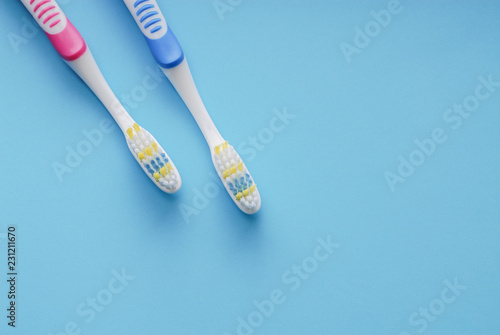 Pink and blue toothbrushes on blue.