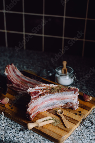  raw meat on wooden cutting board on dark background