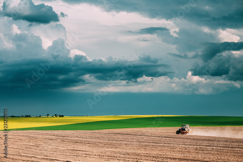 Tractor Plowing Field In Spring Season. Beginning Of Agricultura photo