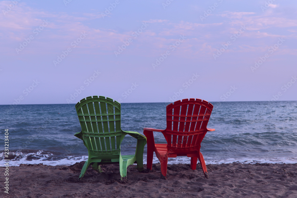 Two lounge chairs on the beach. Half a turn on a lounger on the beach. Beach loungers in the morning. The concept of rest and relaxation.