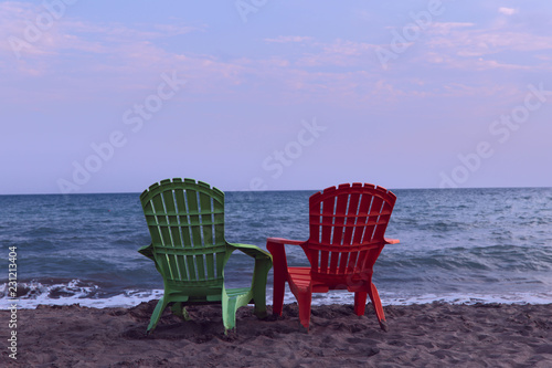 Two lounge chairs on the beach. Half a turn on a lounger on the beach. Beach loungers in the morning. The concept of rest and relaxation. © Nataliia