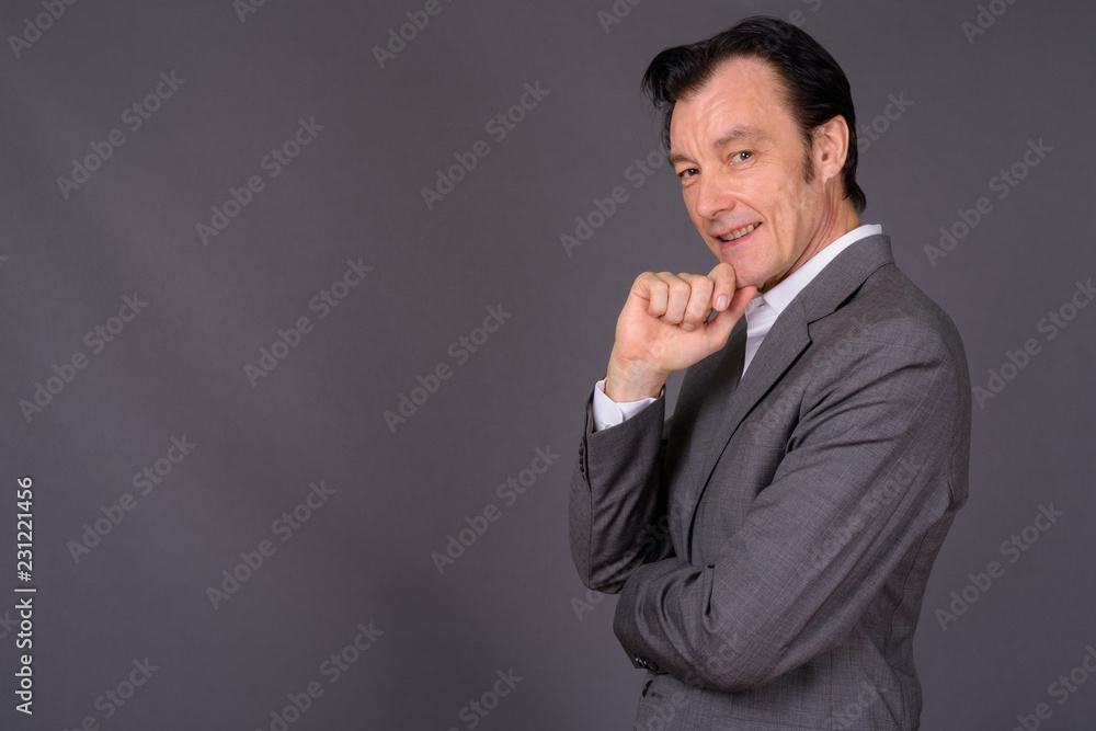 Portrait of mature handsome businessman against gray background Portrait of mature handsome businessman against gray background