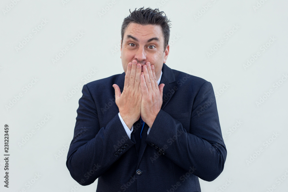 Positive embarrassed businessman covering mouth with hands and looking at camera. Content middle-aged man awing. Cute man concept Positive embarrassed businessman covering mouth with hands and looking at camera. Content middle-aged man awing. Cute man concept