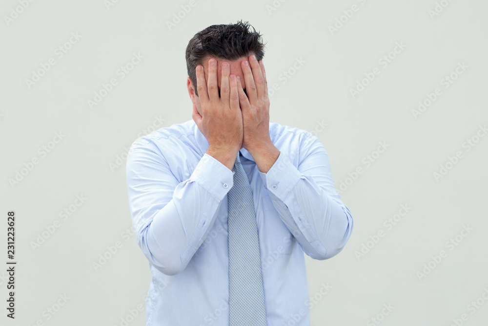 Upset businessman covering face with hands while crying. Sad man in formal shirt suffering from failure. Stress concept Upset businessman covering face with hands while crying. Sad man in formal shirt suffering from failure. Stress concept