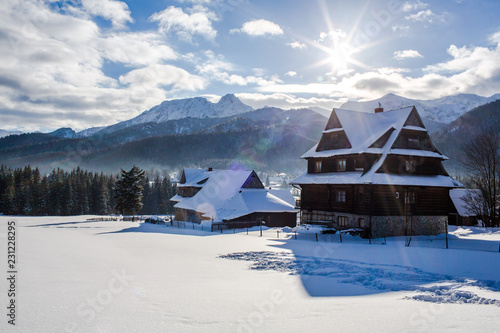 Traditional wooden houses in the background of the winter mountains in the ski resort of Zakopane, Koscielisko, Poland