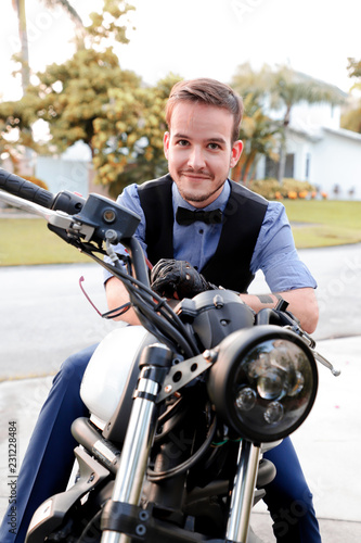 Friendly guy on a motorcycle smiling at the camera in the evening outdoor © Light name