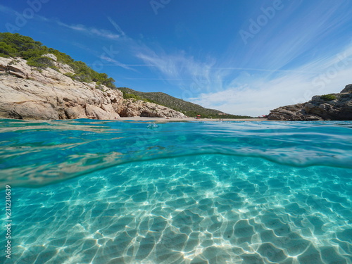 Fototapeta Naklejka Na Ścianę i Meble -  Beach and rock on seashore with sand underwater, split view half above and below water surface, Mediterranean sea, Spain, Costa Dorada, Platja Del Torn, l'Hospitalet de l'Infant, Tarragona, Catalonia