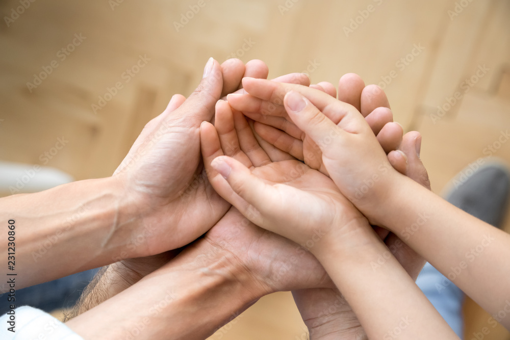 Vertical view family hands palms holding together. Mother daughter father arms close up. Concept of support love and unity, understanding and devotion, bonding and relatives people warm relationships Vertical view family hands palms holding together. Mother daughter father arms close up. Concept of support love and unity, understanding and devotion, bonding and relatives people warm relationships