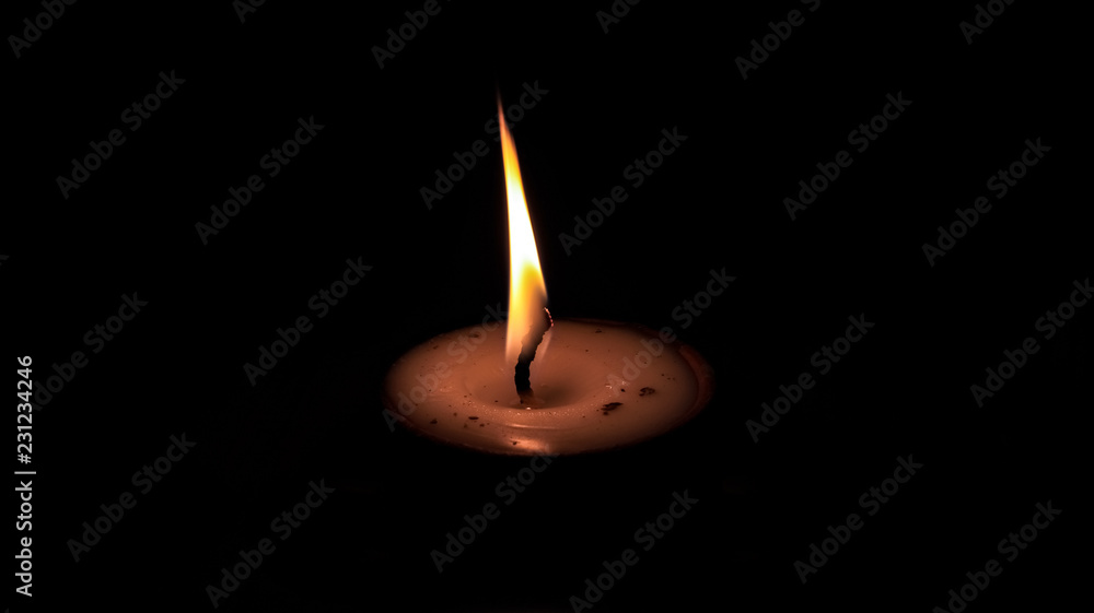 One butter lamp candle glowing in the dark, mainly used during Diwali or Deepawali festival One butter lamp candle glowing in the dark, mainly used during Diwali or Deepawali festival