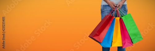 Composite image of low section of man carrying colorful shopping
