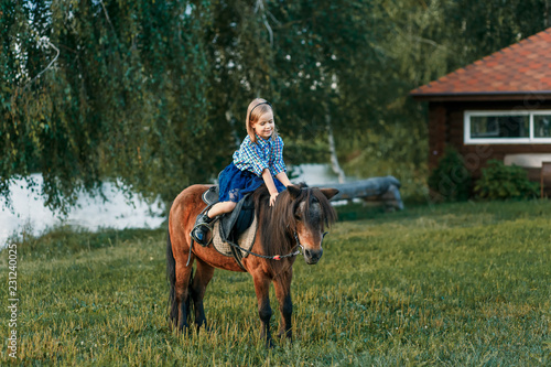 A girl and a pony outside at sunset. Nature near the water