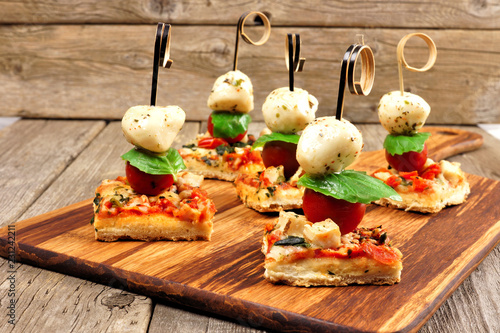 Photography Caprese pizza skewers with mozzarella, basil, and tomatoes