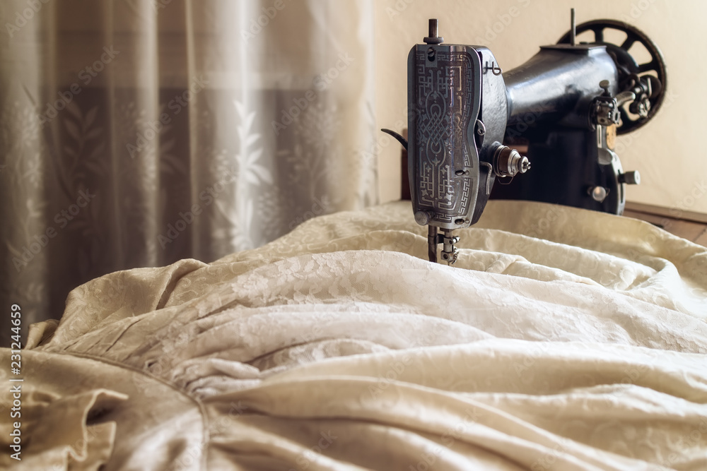 Vintage sewing machine making a traditional old bride dress in an italian home - obrazy, fototapety, plakaty 