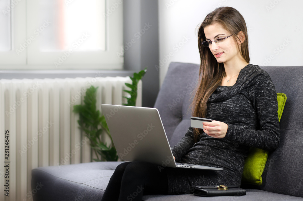 Young beautiful woman with glasses doing online shopping at home Young beautiful woman with glasses doing online shopping at home