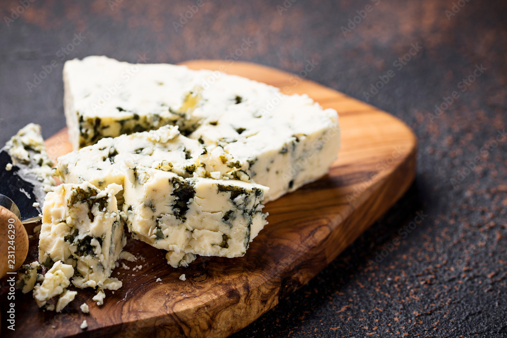 Blue cheese and knife on cutting board Blue cheese and knife on cutting board