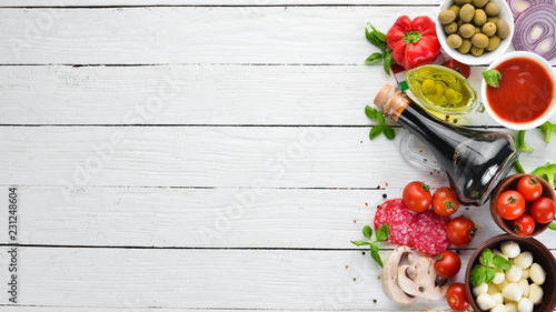 Food Background. Mushrooms, cheese, sausages, tomatoes, vegetables. Top view. On a wooden background. Free copy space.