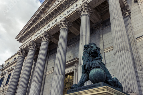 Main facade of the Spanish Parliament House with one lion flanking the entrance (Madrid, Spain)