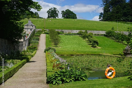 Blair Athol, Scotland: Sheep grazing under a bright blue sky on a hillside over the garden at Blair Castle, a 13th-century stronghold in the Scottish Highlands. photo