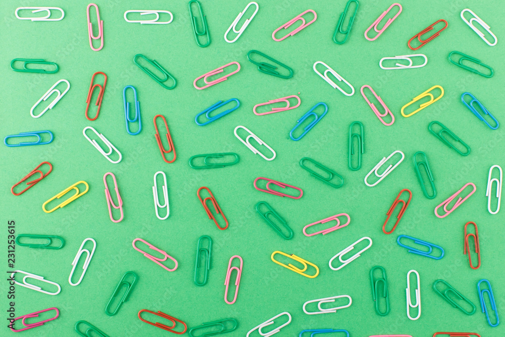 Background made from colored paper clips on the light green base Background made from colored paper clips on the light green base