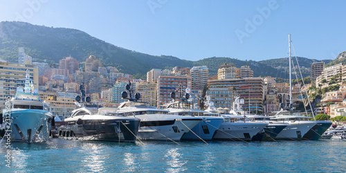 Yachts moored in Monaco harbour with Monaco landscape on a background