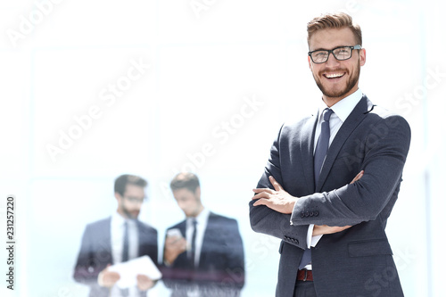 smiling businessman on blurred office background