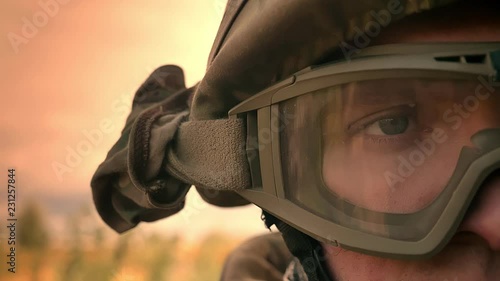 Close-up right eye of caucasian male in military helmet, looking straight at camera standing outdoor, in sunlights isolated