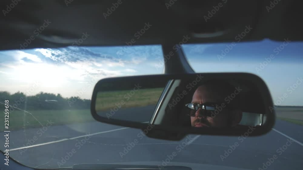 Young man driving a car. Man sitting and driving in the car. Trip of a in sunny weather. Young man driving a car. Man sitting and driving in the car. Trip of a in sunny weather.
