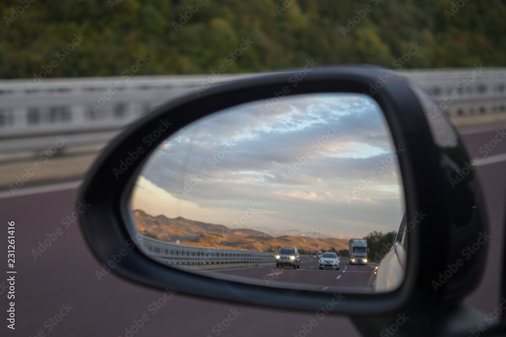 Highway view from car rear view mirror, car on the road