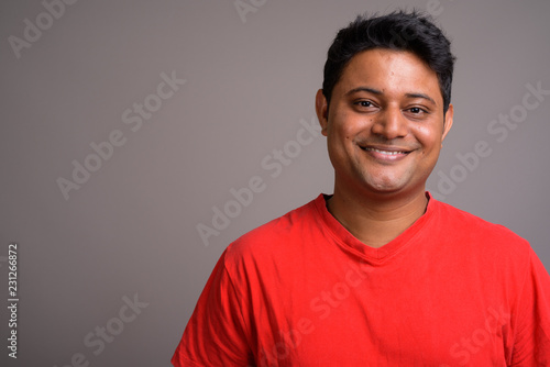 Portrait of young Indian man against gray background © Ranta Images