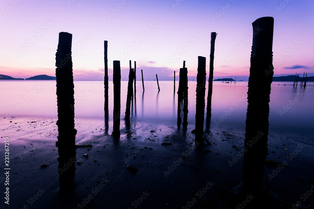 Long exposure image of Dramatic sky seascape with Old wooden pole in the sea sunset or sunrise scenery background. Long exposure image of Dramatic sky seascape with Old wooden pole in the sea sunset or sunrise scenery background.