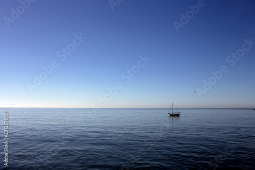 Sailboat at mooring in harbor on calm water
