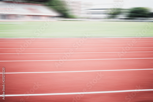 Empty Red Running track texture with lane background copy space, nobody runner tracks athietic competition in sunny day. Motion Blur race for training sport