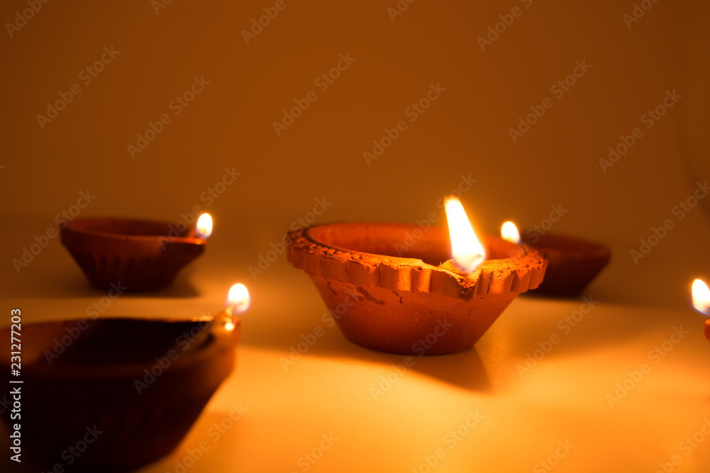 Diwali terracotta diyas on dark background which are used lighting up the house during diwali celebrations. Diwali terracotta diyas on dark background which are used lighting up the house during diwali celebrations.