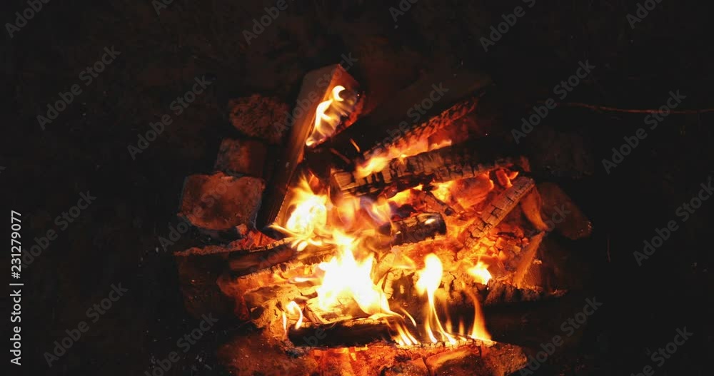 Top view on the fire burning brightly and glowing in the dark. Close up. Outside. Top view on the fire burning brightly and glowing in the dark. Close up. Outside.