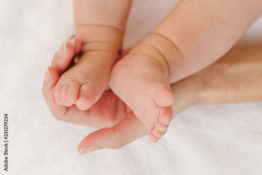 Baby feet in mamas hands - mother's love concept Baby feet in mamas hands - mother's love concept