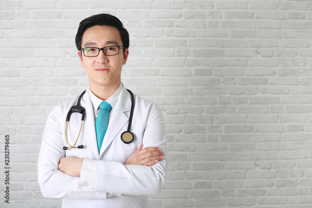 Doctor posing with arms crossed, medical staff working on blurry background. Doctor posing with arms crossed, medical staff working on blurry background.