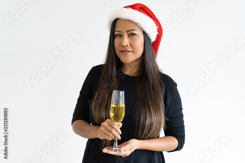 Portrait of confident businesswoman with champagne flute. Mid adult Asian woman celebrating New Year. Christmas and New Year party concept