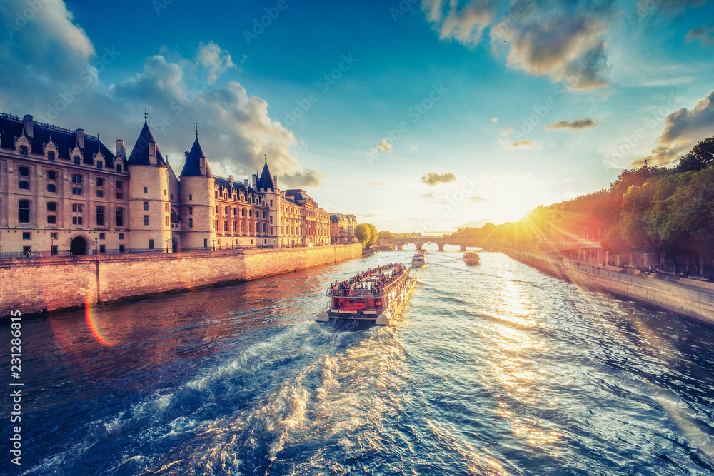 Naklejka premium Dramatyczny zachód słońca nad Sekwaną w Paryżu, we Francji, z Conciergerie i Pont Neuf. Kolorowe tło podróży. Romantyczny pejzaż.