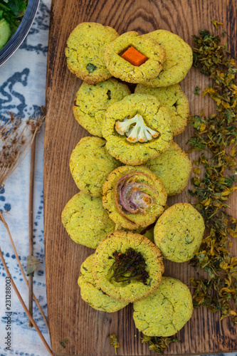 Golden crispy corn breads with vegetables and herbs baked in oven on wooden board. Vegan vegetarian healthy food, paleo diet. Mchadi - traditional Georgian bread