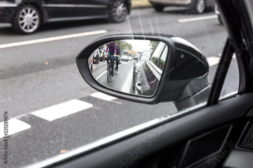 Konstfotografi Cyclist in the exterior mirror of a car